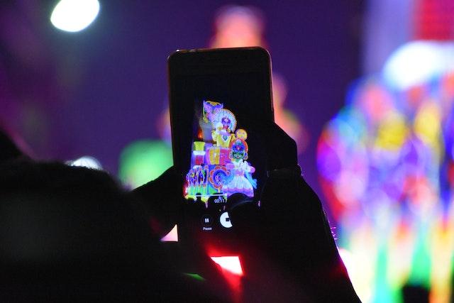 Persona tomando una foto con un teléfono por la noche